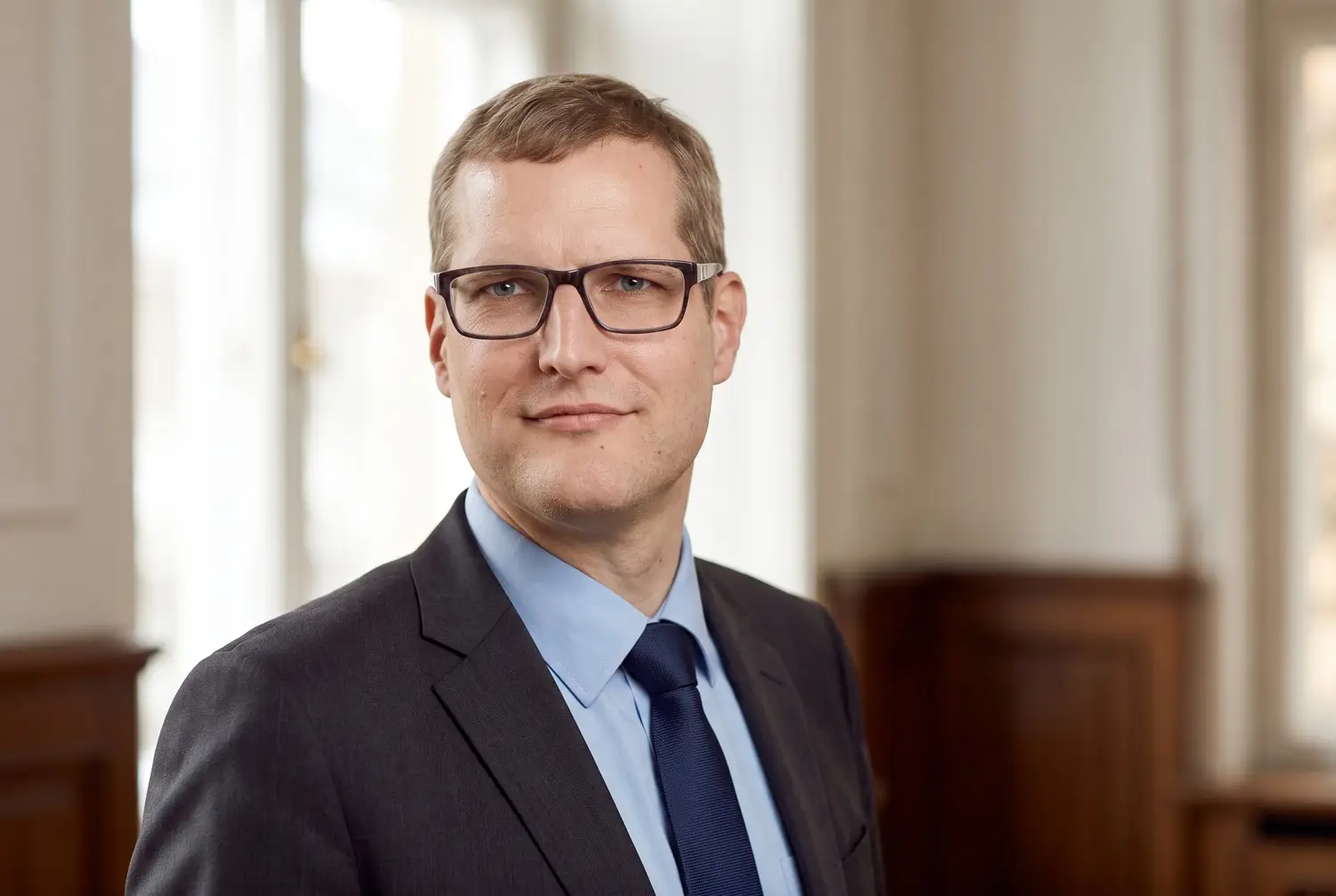 Mann mit Brille und Anzug